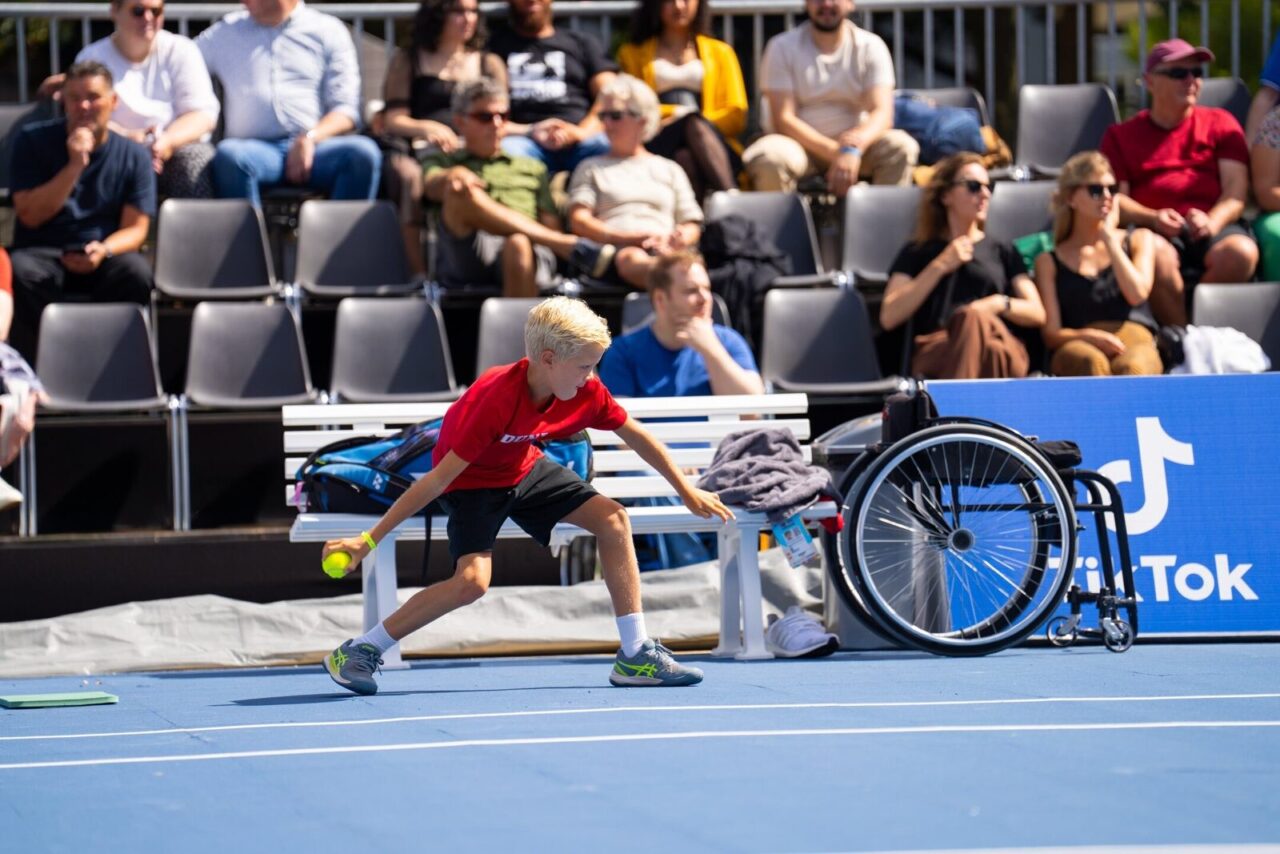 A ball kid retrieves a ball during a wheelchair tennis match at EPC 2023.